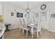 Classic dining room with a white table, six chairs, wood floors, a modern chandelier, and natural light at 4927 Sandlewood Dr., Myrtle Beach, SC 29579