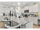Bright, open kitchen features a granite island, stainless appliances, and white cabinetry with stylish pendant lighting at 4927 Sandlewood Dr., Myrtle Beach, SC 29579