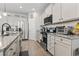 Well-lit kitchen boasting stainless steel appliances, granite countertops, white cabinetry, and hardwood flooring at 4927 Sandlewood Dr., Myrtle Beach, SC 29579