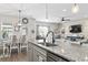 Open-concept kitchen features granite island, stainless sink, and seamless flow into dining and living areas at 4927 Sandlewood Dr., Myrtle Beach, SC 29579