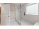 Sleek bathroom features a glass shower, white marble-style tiles, and a window for natural light at 5031 Vinesia Dr., Myrtle Beach, SC 29579