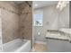 Bathroom featuring tub with tiled walls, vanity with granite countertop, and natural light from window at 505 Beaty St., Conway, SC 29526