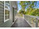 Outdoor deck with wooden flooring, white railing, and views of the trees in backyard at 505 Beaty St., Conway, SC 29526