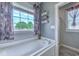 Bright bathroom with gray walls, a tub with a view to the exterior, and towel racks at 548 Fox Chase Dr., Conway, SC 29527
