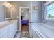 Bright bathroom with gray walls, a tub, double sinks, and a view into the bedroom at 548 Fox Chase Dr., Conway, SC 29527