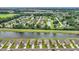 Aerial view showcasing the neighborhood's layout, pond, pools, and the nearby city skyline at 553 Pier Ct., Longs, SC 29568