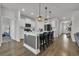 Spacious kitchen with white cabinets, a gray island with seating, and hardwood floors at 553 Pier Ct., Longs, SC 29568
