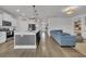 Open-concept living room with modern kitchen, hardwood floors, and a comfortable blue sofa at 553 Pier Ct., Longs, SC 29568