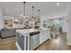 Open layout featuring a modern kitchen island, living room, and dining area with natural light at 553 Pier Ct., Longs, SC 29568