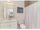 Well-lit bathroom with white vanity, toilet, shower with curtain, and a decorative painting at 5750 Oyster Catcher Dr. # 531, North Myrtle Beach, SC 29582