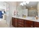 Double sink bathroom vanity with brown wood cabinets and decoratively accented walls at 5822 Longwood Dr. # 104, Murrells Inlet, SC 29576