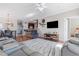 Spacious living room with hardwood floors, reclining seating, TV, and adjacent dining area, offering a cozy atmosphere at 5822 Longwood Dr. # 104, Murrells Inlet, SC 29576