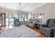 Bright living room with modern reclining seating, large windows, and hardwood floors covered by a patterned area rug at 5822 Longwood Dr. # 104, Murrells Inlet, SC 29576