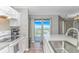 Kitchen featuring white cabinets, stainless steel sink, balcony access with a view, and tile flooring at 5905 S Kings Hwy. # 1816 Rt, Myrtle Beach, SC 29575