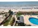 Aerial view of community pool surrounded by lush greenery, sun loungers, and beach access at 5905 S Kings Hwy. # 1816 Rt, Myrtle Beach, SC 29575