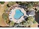 Aerial view of the community pool with lounge chairs and tables surrounded by lush landscaping and fencing at 703 Riverwalk Dr. # 303, Myrtle Beach, SC 29579