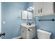 Compact blue and white bathroom features a modern vanity, toilet, and mirror, maximizing space and style at 703 Riverwalk Dr. # 303, Myrtle Beach, SC 29579