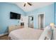 Cozy blue bedroom with TV and neutral furnishings, leading to a bathroom and closet, offering comfort and convenience at 703 Riverwalk Dr. # 303, Myrtle Beach, SC 29579