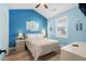 Serene blue bedroom features a plush queen bed, a window providing natural light, and tasteful nautical artwork at 703 Riverwalk Dr. # 303, Myrtle Beach, SC 29579