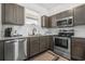 Modern kitchen features stainless steel appliances, gray cabinets, granite countertops, and ample natural light at 703 Riverwalk Dr. # 303, Myrtle Beach, SC 29579
