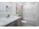 Bright bathroom featuring a vanity with marble countertop, toilet, and shower-tub combination with a decorative curtain at 8204 S Highway 905, Longs, SC 29568