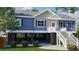 Lovely blue house with white trim, stairs, and carport offers great curb appeal at 8204 S Highway 905, Longs, SC 29568