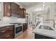 Bright kitchen boasts white marble countertops, stainless appliances, and classic cherry wood cabinets at 853 Bluffview Dr., Myrtle Beach, SC 29579