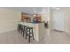 Open-concept kitchen featuring a breakfast bar with stools, tile floors, and ample natural light at 905 Sewing Bee Pl., Little River, SC 29566