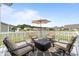 This outdoor patio features a fire pit, chairs, and an umbrella at 905 Sewing Bee Pl., Little River, SC 29566