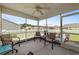 This screened porch features chairs and a ceiling fan at 905 Sewing Bee Pl., Little River, SC 29566