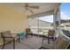 This screened porch features chairs and a ceiling fan at 905 Sewing Bee Pl., Little River, SC 29566