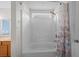 White tiled shower and tub with shower curtain and small window above at 905 Sewing Bee Pl., Little River, SC 29566