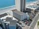 An aerial shot shows a condo building with a parking lot near the beach at 920 N Waccamaw Dr. # 1302, Garden City Beach, SC 29576