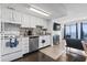 Updated kitchen with white cabinets, stainless steel appliances, and a cozy living area with ocean view at 920 N Waccamaw Dr. # 1302, Garden City Beach, SC 29576