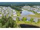 Aerial view of a residential area showcasing houses, trees, and a serene pond with lush greenery at 933 Wild Leaf Loop, Conway, SC 29526