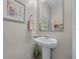Cozy powder room with a pedestal sink, decorative mirror, and coastal-themed decor for a touch of charm at 933 Wild Leaf Loop, Conway, SC 29526