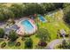 A beautiful aerial shot of a community pool, shuffleboard, basketball court, and playground surrounded by lush greenery at 1009 Hopscotch Ln., Conway, SC 29526