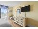 Well-lit bedroom boasts a television, balcony, and dresser at 1207 S Ocean Blvd. # 51001, Myrtle Beach, SC 29577