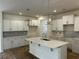 Modern kitchen featuring white cabinetry, herringbone backsplash, and a central island with quartz countertop at 126 Westfield Circle, Conway, SC 29526