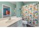 The turquoise bathroom is tiled with a bright shower curtain and white cabinets at 131 Waypoint Ridge Ave. # Q26, Little River, SC 29566