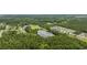 Aerial view highlighting a serene lake surrounded by lush greenery and residences at 1342 Highway 90, Conway, SC 29526