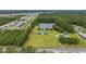Aerial view showcases a private lake, green space, wooded area, and neighboring homes at 1342 Highway 90, Conway, SC 29526