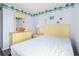A coastal bedroom featuring bright yellow dresser, white linens, and beach accents at 1425 S Ocean Blvd. # 2A, North Myrtle Beach, SC 29582