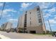 Street view of the condo building with palm trees, a parking garage, and neighboring buildings at 1425 S Ocean Blvd. # 2A, North Myrtle Beach, SC 29582