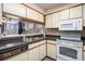 Kitchen featuring dark countertops, white cabinets, and an adjoining view to the living room and balcony at 1425 S Ocean Blvd. # 2A, North Myrtle Beach, SC 29582