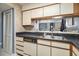 A charming kitchen with stainless steel sink, wood cabinets, and black countertops at 1425 S Ocean Blvd. # 2A, North Myrtle Beach, SC 29582