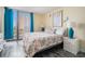 A cozy main bedroom with a floral-patterned bedspread and beautiful natural light at 1425 S Ocean Blvd. # 2A, North Myrtle Beach, SC 29582