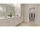 Well-lit bathroom with double vanity, large mirror, and a walk-in closet at 144 Warner Crossing Way, Loris, SC 29569