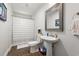 Cozy bathroom with white pedestal sink, framed mirror and shower with striped curtain at 1936 Lees Landing Circle, Conway, SC 29526