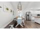 Dining area with a long table with bench seating and modern lighting fixture, adjacent to the kitchen at 1936 Lees Landing Circle, Conway, SC 29526